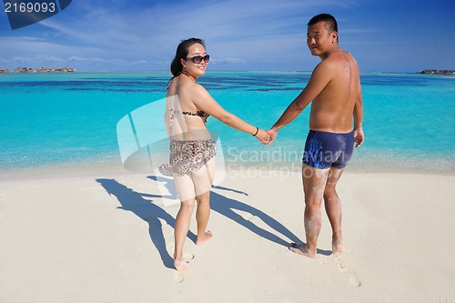 Image of happy young  couple enjoying summer on beach