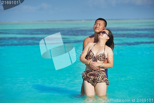 Image of happy young  couple enjoying summer on beach