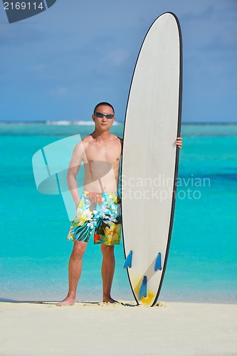 Image of Man with surf board on beach