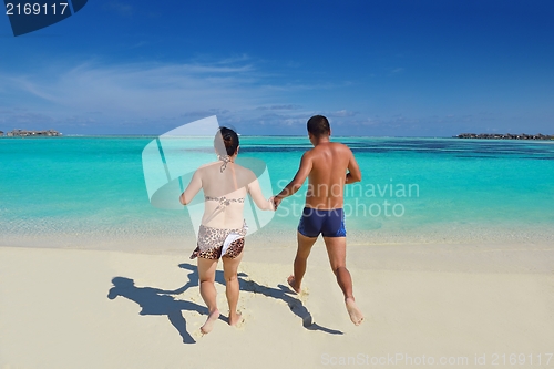 Image of happy young  couple enjoying summer on beach