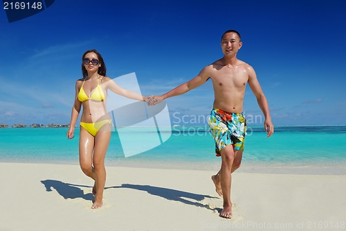 Image of happy young  couple enjoying summer on beach