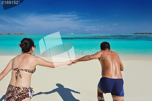 Image of happy young  couple enjoying summer on beach