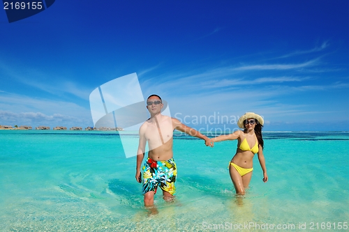 Image of happy young  couple enjoying summer on beach