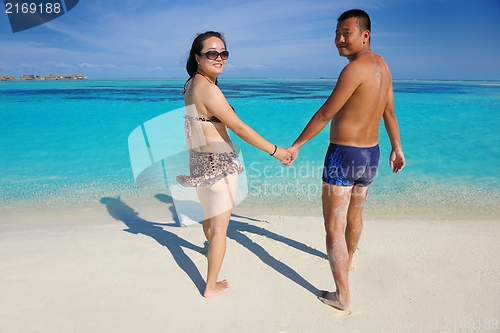 Image of happy young  couple enjoying summer on beach