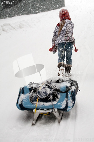 Image of little girl dragging big sled