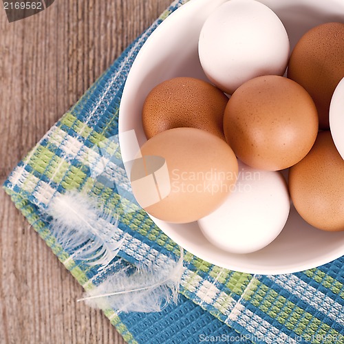 Image of eggs in a bowl, towel and feathers