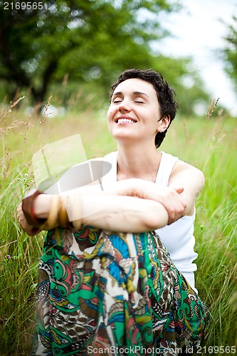 Image of  cute girl resting on fresh spring grass 