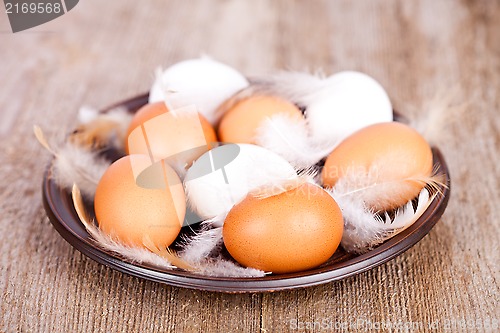 Image of eggs and feathers in a plate 