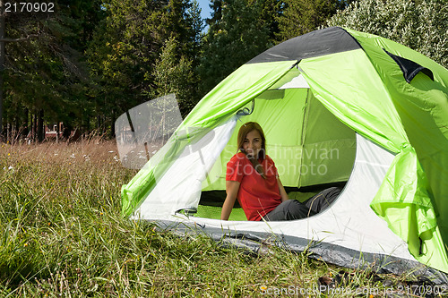 Image of girl in a red dress in a tent in a forest