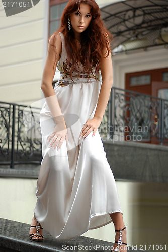 Image of woman in long dress near a hotel