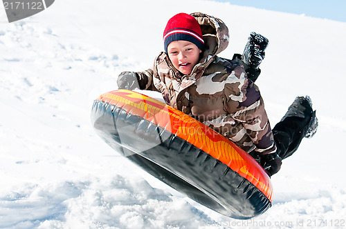 Image of Boy up in the air on a tube in the snow