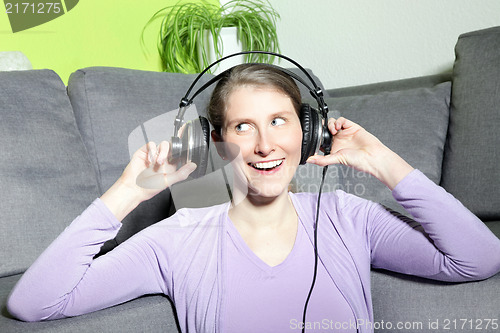 Image of Laughing mature woman listening to music