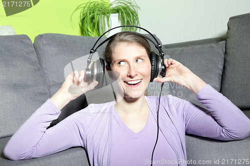 Image of Laughing mature woman listening to music