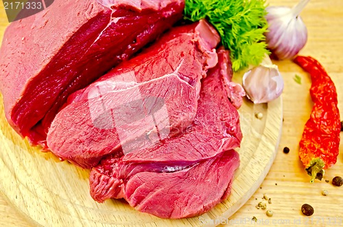 Image of Meat beef on a wooden board with vegetables