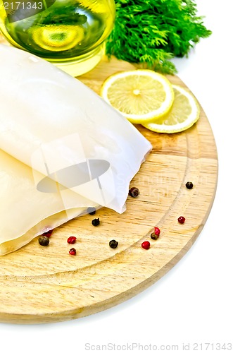 Image of Squid with lemon and oil on a round board