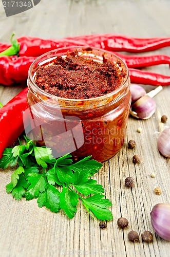 Image of Ajika in a glass jar on the old board