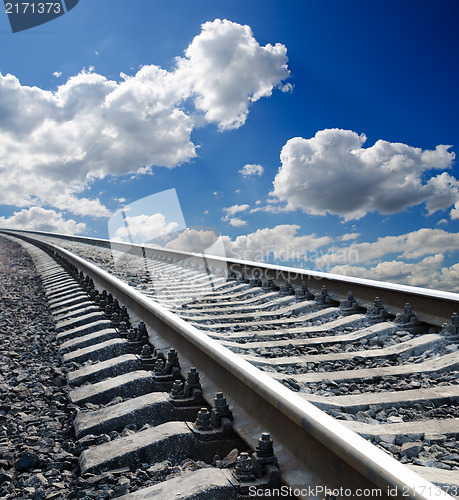 Image of low view to railroad under deep blue cloudy sky