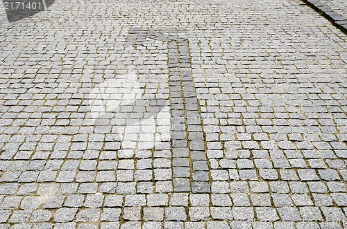 Image of cobbled road with arrow