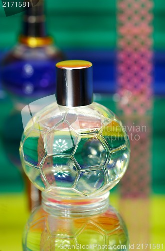 Image of Glass bottles with perfumery. On a color background with reflect