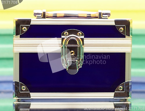 Image of  Dark blue steel small suitcase with the lock on a multi-coloure