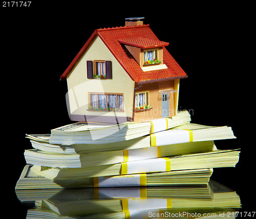 Image of house on packs of banknotes