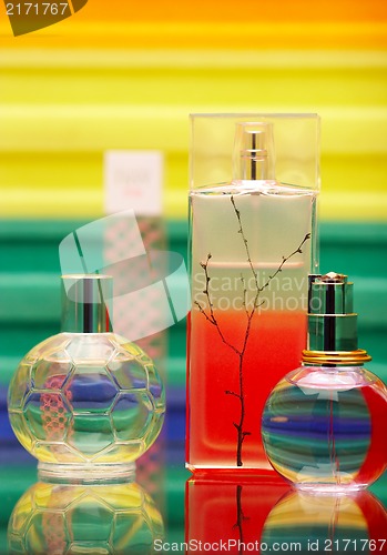 Image of Glass bottles with perfumery. On a color background with reflection.