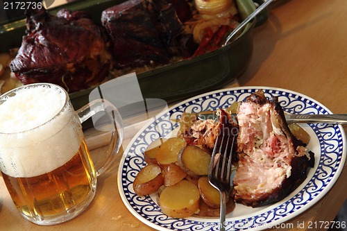 Image of roasted pork knuckle with potatoes and beer