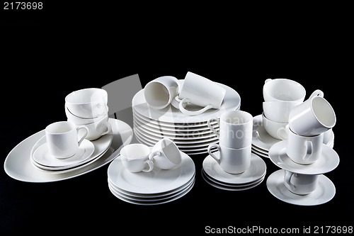 Image of mixed white dishes cups and plates isolated on black