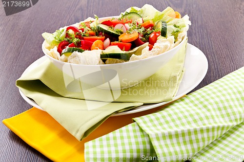 Image of fresh mixed colorful salad on wooden table 