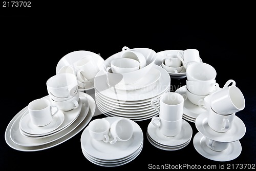 Image of mixed white dishes cups and plates isolated on black