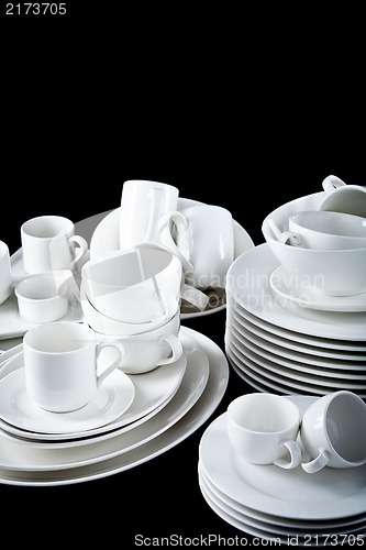 Image of mixed white dishes cups and plates isolated on black