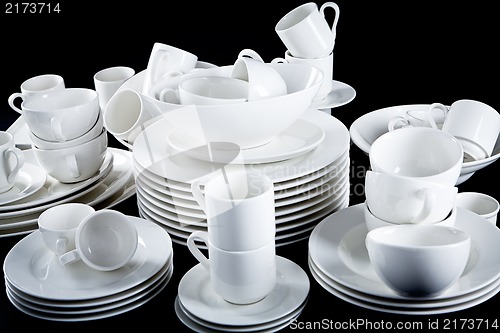 Image of mixed white dishes cups and plates isolated on black