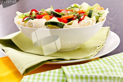 Image of fresh mixed colorful salad on wooden table 