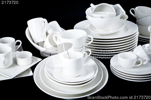 Image of mixed white dishes cups and plates isolated on black