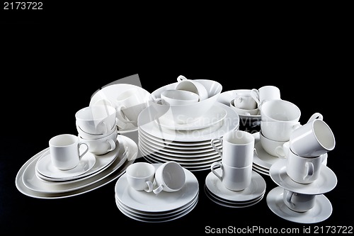 Image of mixed white dishes cups and plates isolated on black