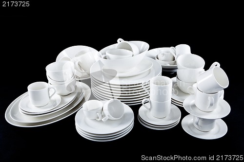 Image of mixed white dishes cups and plates isolated on black