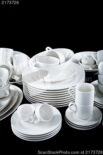 Image of mixed white dishes cups and plates isolated on black