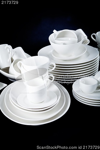 Image of mixed white dishes cups and plates isolated on black