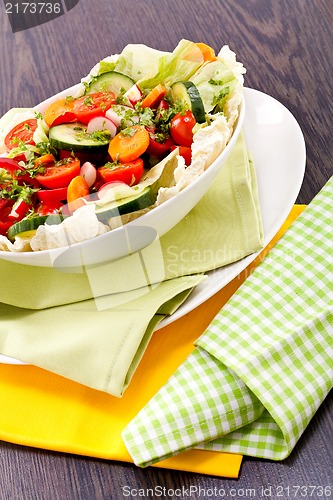 Image of fresh mixed colorful salad on wooden table 