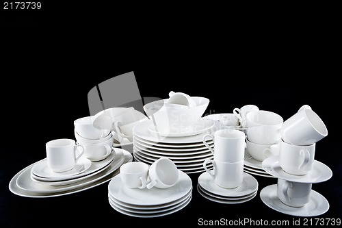 Image of mixed white dishes cups and plates isolated on black