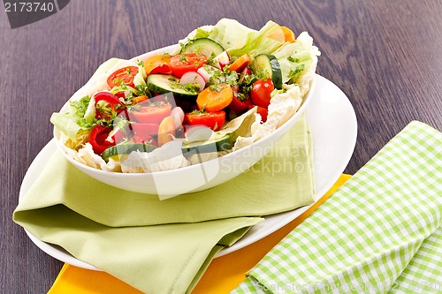 Image of fresh mixed colorful salad on wooden table 