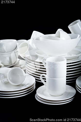 Image of mixed white dishes cups and plates isolated on black