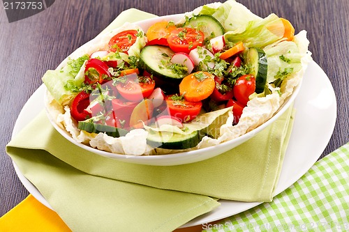 Image of fresh mixed colorful salad on wooden table 