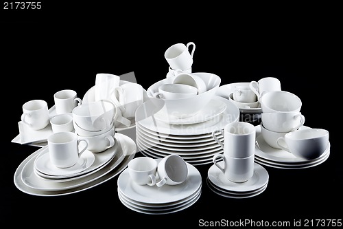 Image of mixed white dishes cups and plates isolated on black