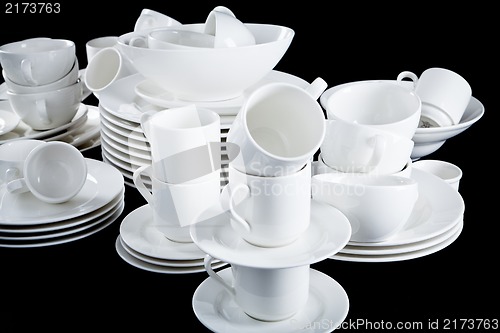 Image of mixed white dishes cups and plates isolated on black