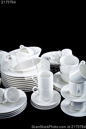 Image of mixed white dishes cups and plates isolated on black