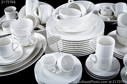 Image of mixed white dishes cups and plates isolated on black