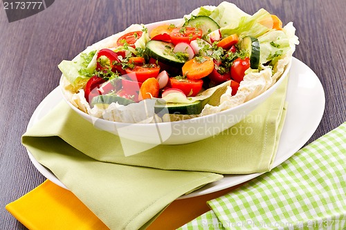 Image of fresh mixed colorful salad on wooden table 