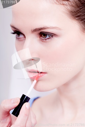 Image of woman applying lipstick on lips natural beauty