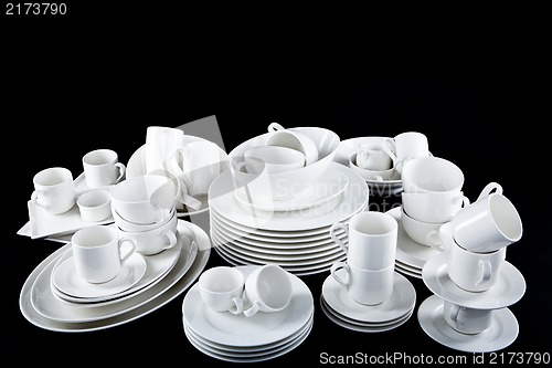 Image of mixed white dishes cups and plates isolated on black